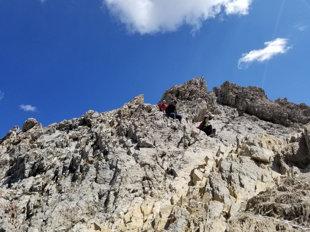 Hikers scrambling down a rocky and jagged section of mountain