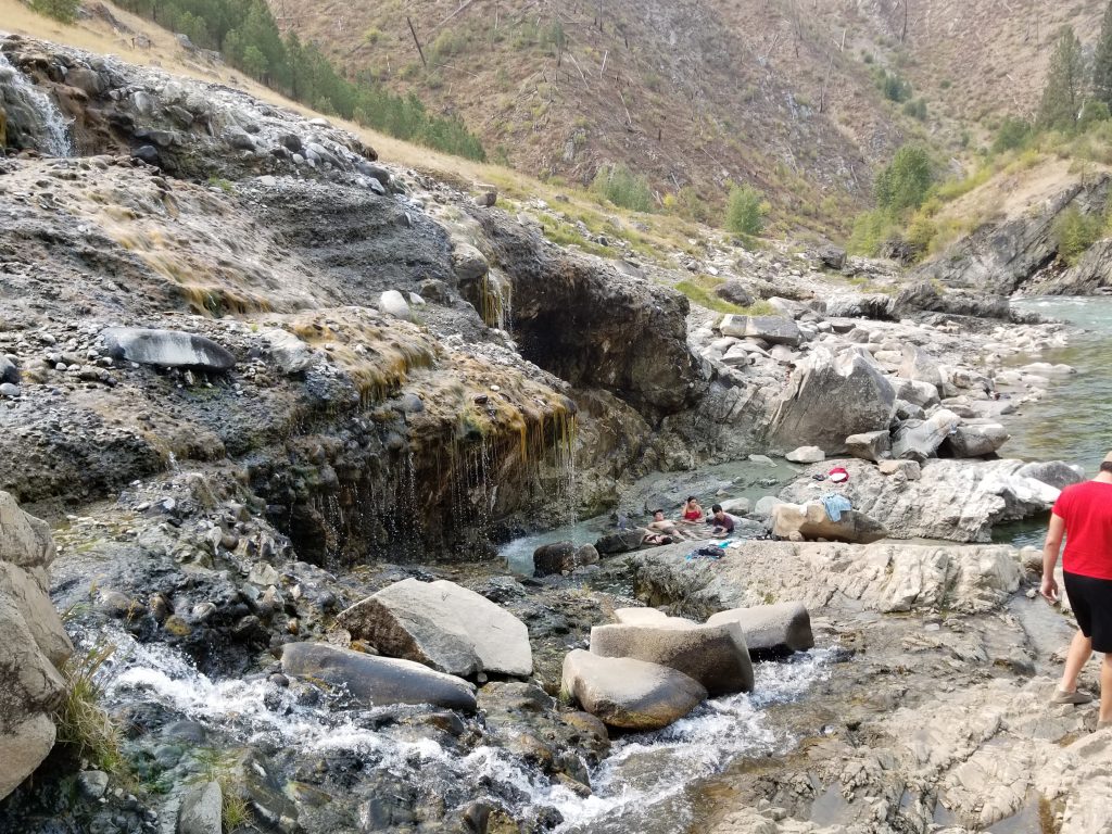 People resting and relaxing in hot springs by river