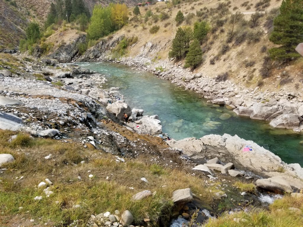 River near grassy slopes that is used as a hot spring
