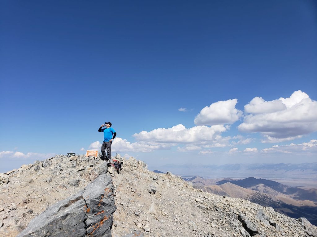 Hiker enjoying a drink at summit