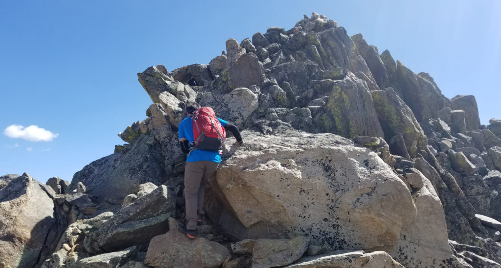 Scrambling on boulder on Un 13001 in Colorado